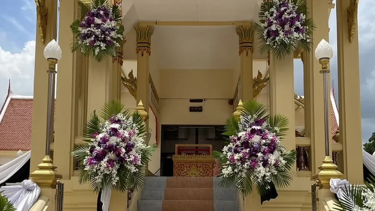 พวงหรีดดอกไม้สดตั้งเรียงสองข้างทางขึ้นศาลาในคืนสวดพระอภิธรรม